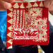 Red and white fabric patchwork held by a person with a blurred background
