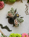 Embroidered bee design on fabric with flowers and beads around