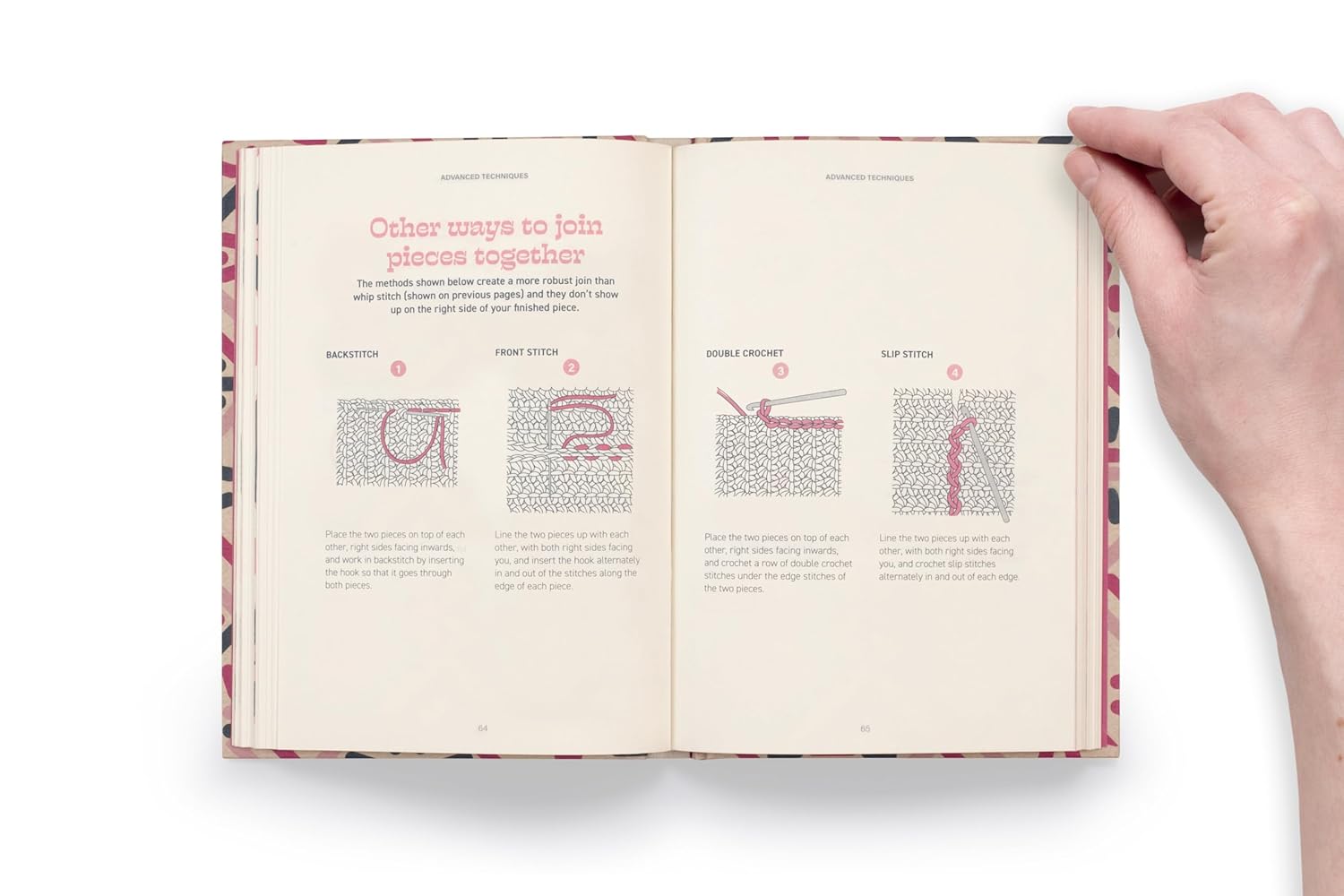 Open book with crochet  instructions held by a hand on a white background