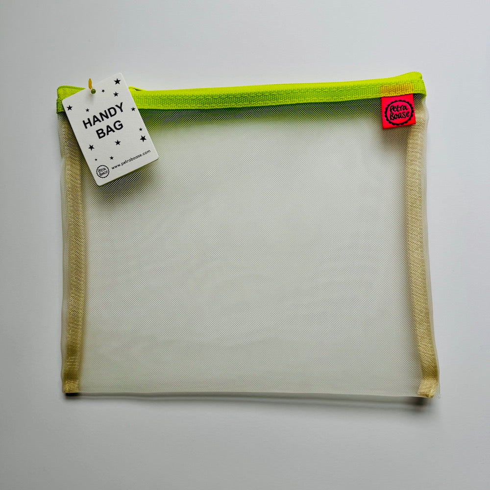 Handy bag with green zipper and tags on a light gray background