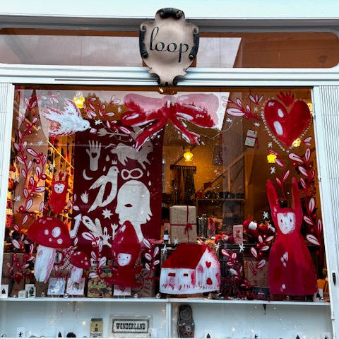Decorative window display with red and white designs, featuring a 'loop' sign above.