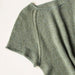 Close-up of a textured knit garment in a muted sage green color, showing the ribbed sleeve and shoulder construction against a plain off-white background.