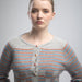 Woman wearing a striped sweater against a plain background