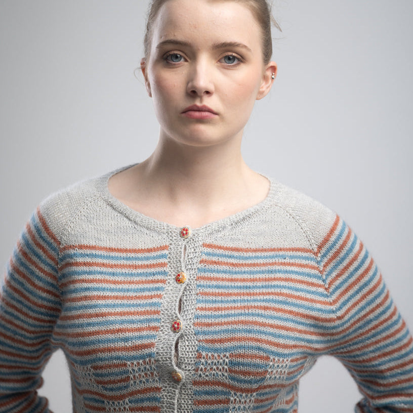 Woman wearing a striped sweater against a plain background