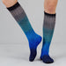 Blue and gray gradient socks worn by a person on a light gray background