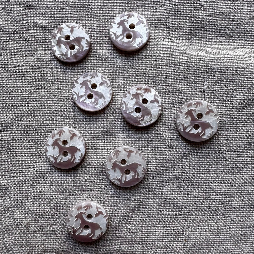 Set of decorative buttons with animal prints on a textured fabric background