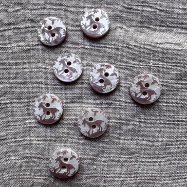 Set of decorative buttons with animal prints on a textured fabric background