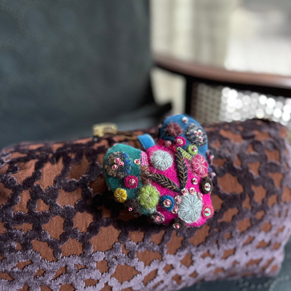 Colorful embroidered butterfly on a patterned fabric surface