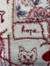 Embroidered fabric with floral patterns and the word 'Hope' in red thread.