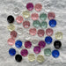 Assorted colorful buttons on a gray fabric background