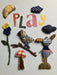 A collection of handmade, patchwork-style fabric toys and decorative cutouts arranged on a light gray background. The set includes a rabbit, a mushroom, a flower, a crescent moon, a ribbon, and the word 'play' spelled out in letters, all crafted from various patterned fabrics.