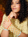 Woman wearing a colorful crocheted wristband against a textured background