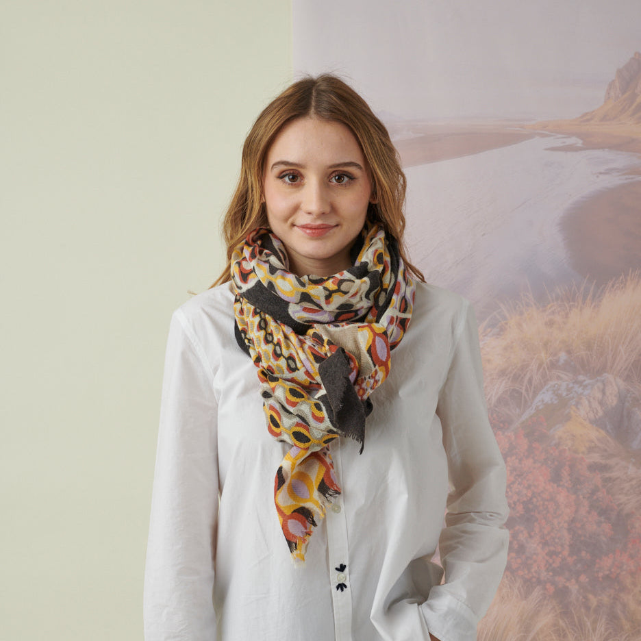 Woman wearing a white shirt and colorful scarf with a blurred background