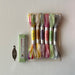Set of colorful embroidery threads in a package on a light background