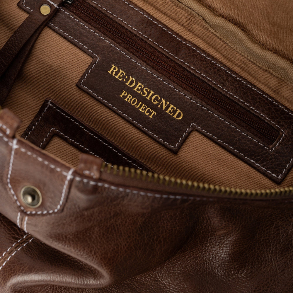 Brown leather bag with 'RE: DESIGNED PROJECT' label
