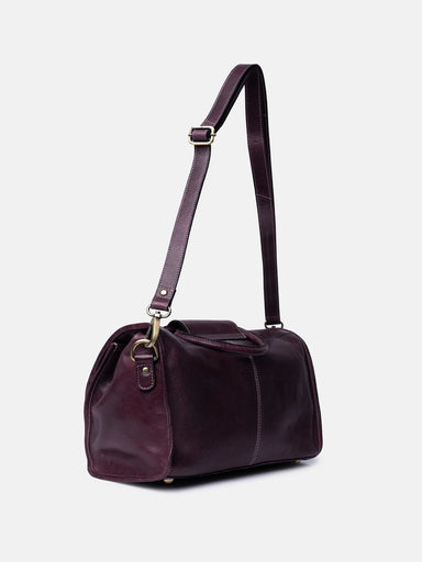 Purple handbag with a strap on a light gray background