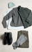 Collection of clothing items including a sweater, jacket, pants, shoes, and socks on a light surface.