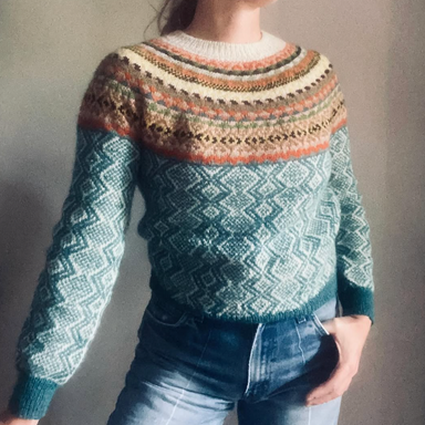 Person wearing a patterned sweater with a neutral background