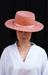 Person wearing a pink hat against a black background