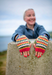 Person wearing colorful knitted gloves outdoors
