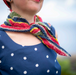 Person wearing a colorful knitted scarf with a blurred background