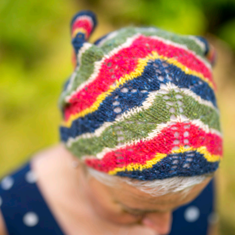 Colorful knitted hat worn by a woman with a blurred natural background