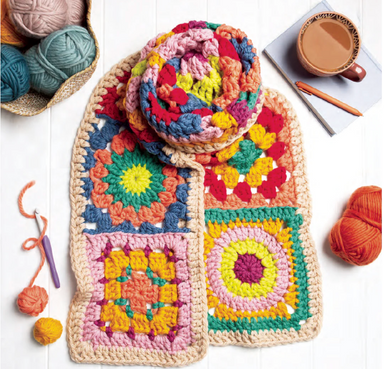 Colorful crocheted squares with yarn and a cup of coffee on a white surface