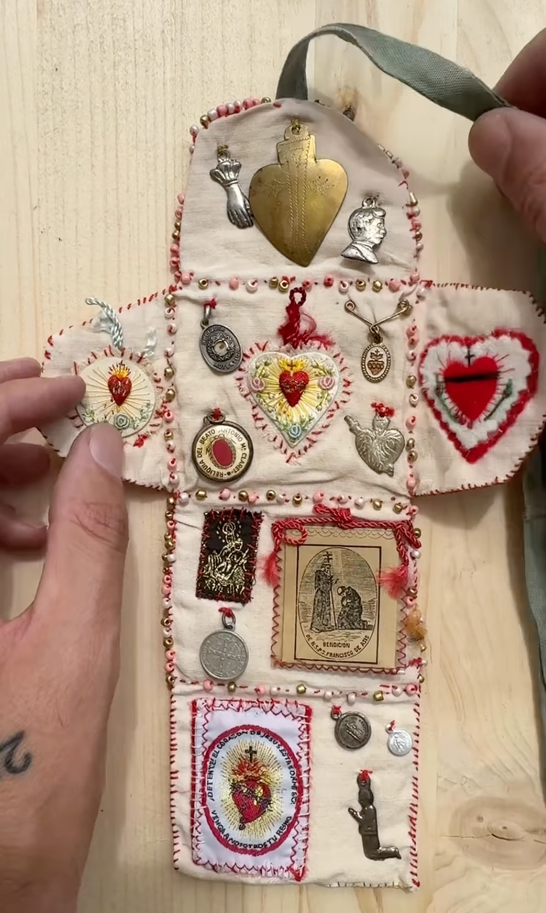 Decorative patchwork pouch with embroidered designs on a wooden surface