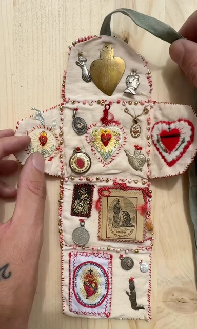 Decorative patchwork pouch with embroidered designs on a wooden surface