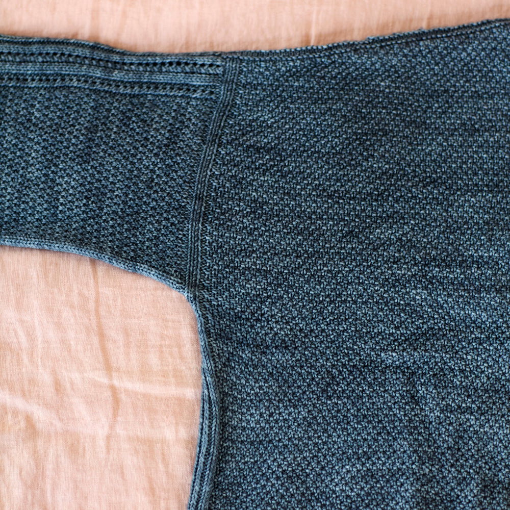 Close-up of blue denim fabric on a beige surface