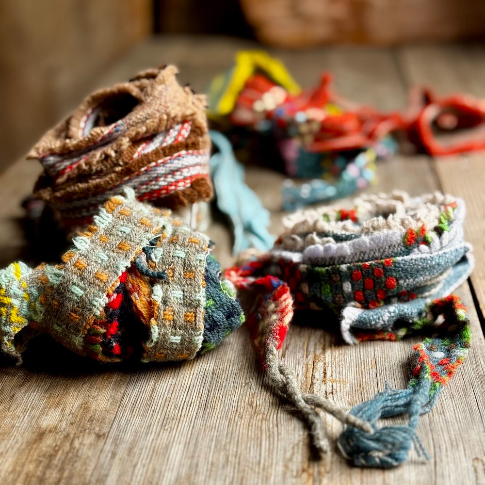 Colorful woven ribbons on a wooden surface