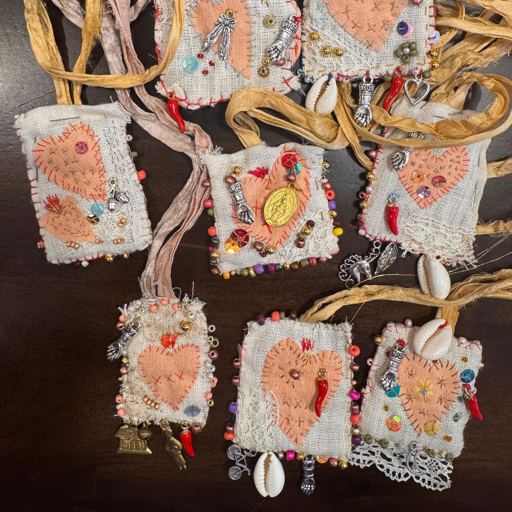 Decorative heart-shaped pouches with embellishments on a dark surface