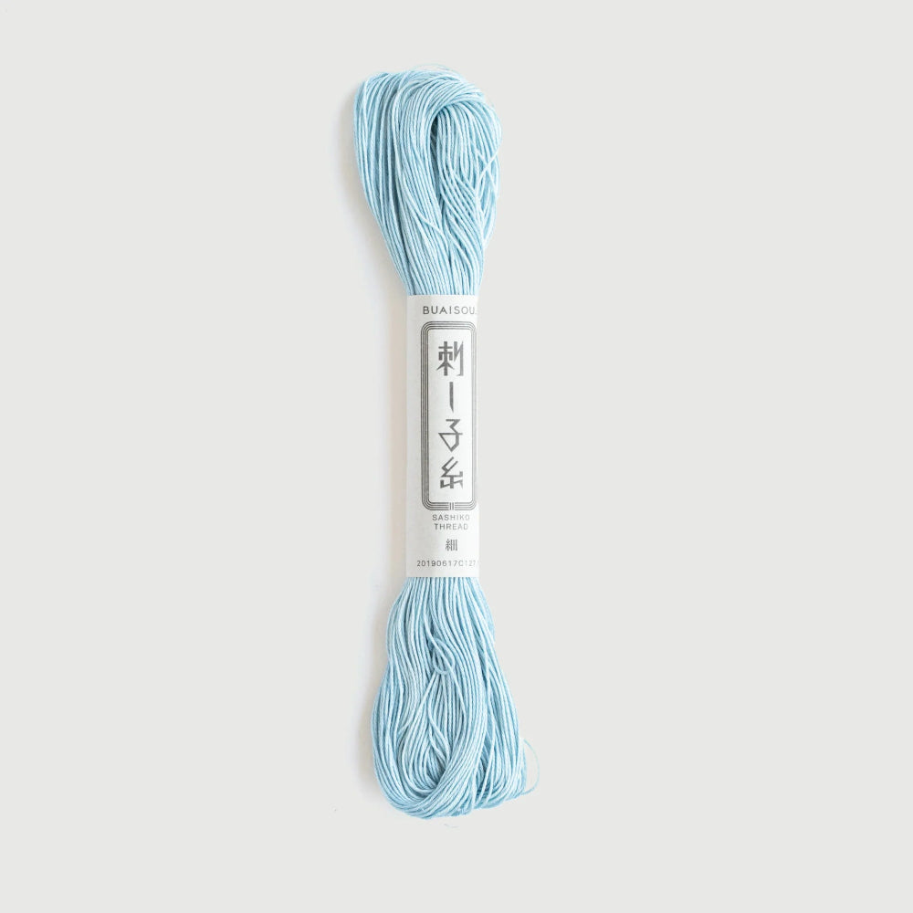Blue yarn skein with a label on a light gray background