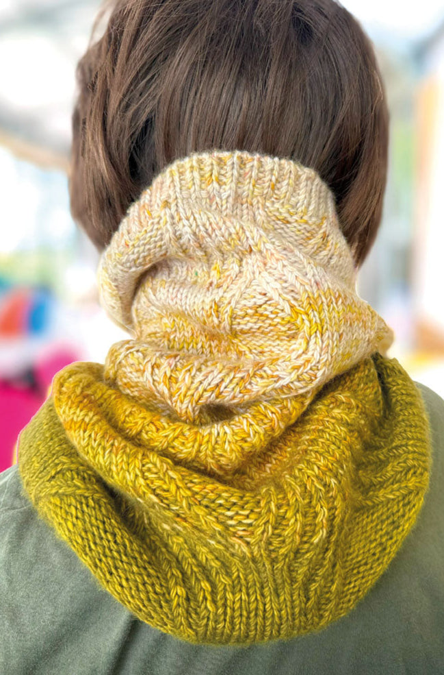 Person wearing a yellow knitted scarf with a blurred background