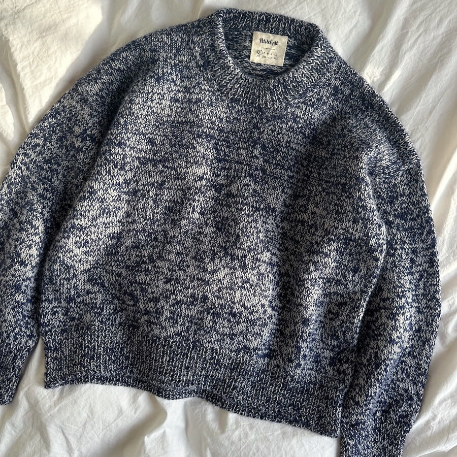 Blue marled sweater on a white fabric background