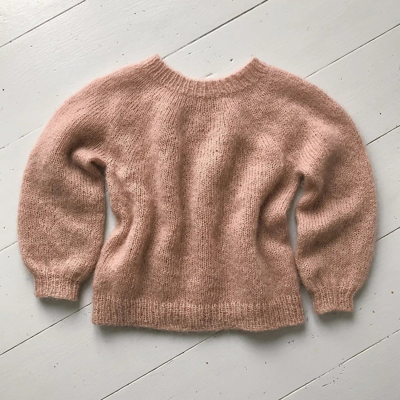 Pink sweater on a light wooden floor