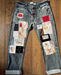 Denim jeans with various patches on a wooden surface