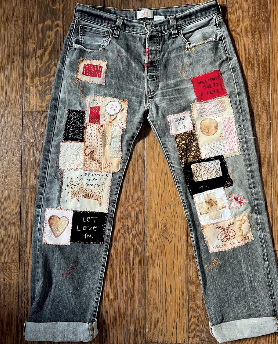 Denim jeans with various patches on a wooden surface
