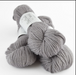 Gray skein of yarn with a label on a white background